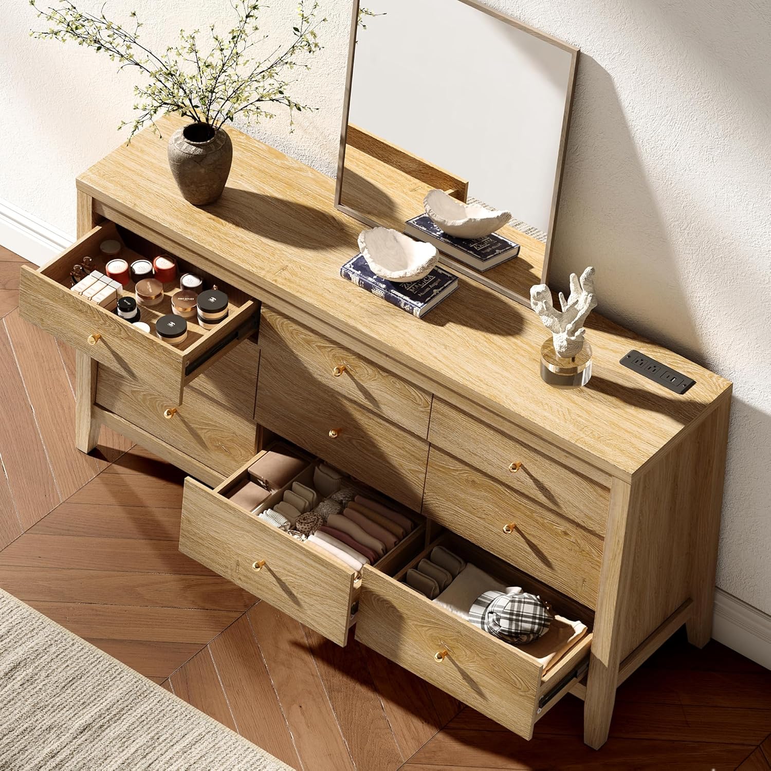 Wooden vanity with open drawers and decorative items on a wooden floor.