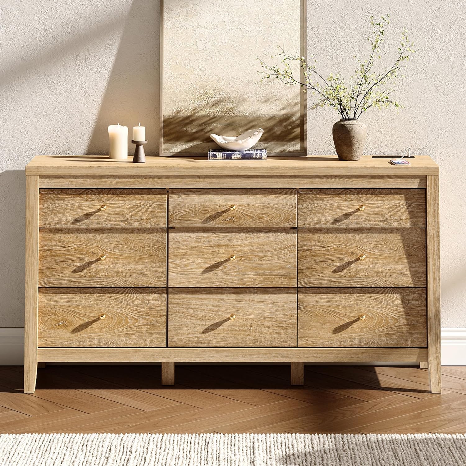 Wooden dresser with decorative items on top against a neutral wall.